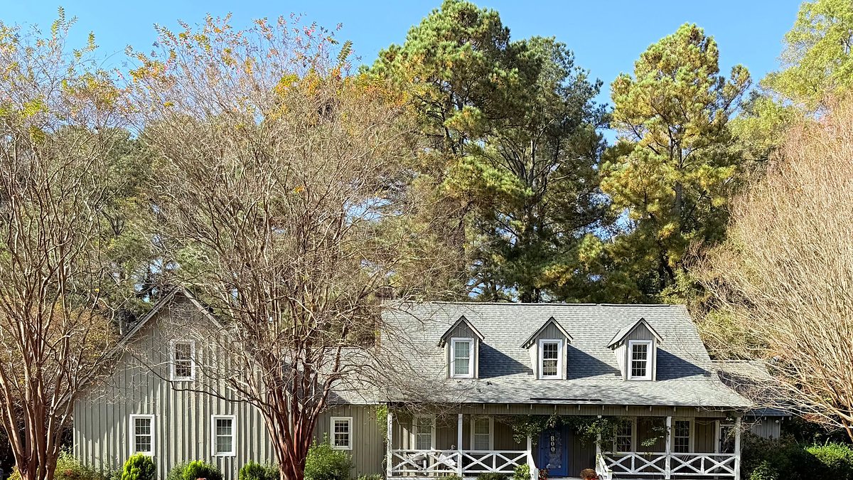 Ranch-style house surrounded by autumn trees and greenery