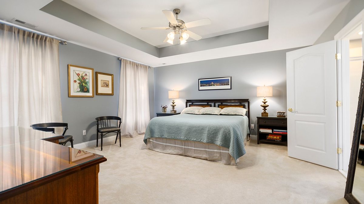 Spacious modern bedroom with a king-size bed, wooden furniture, elegant decor and soft lighting