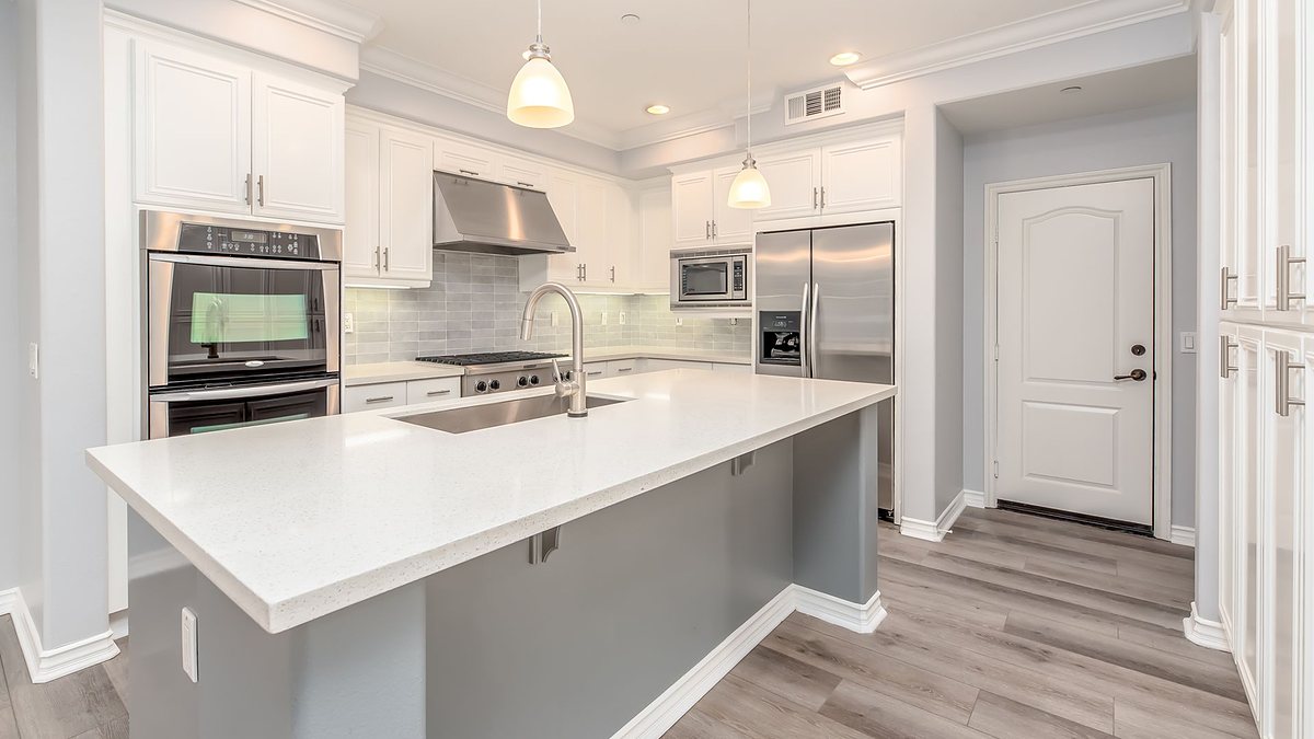 Modern kitchen interior with sleek white cabinetry and stainless steel appliances