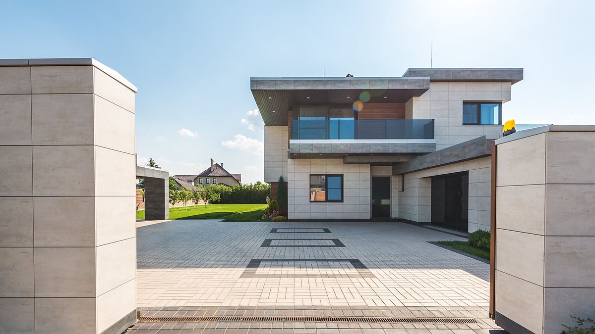 Contemporary two-story luxury home with a spacious paved driveway and garden
