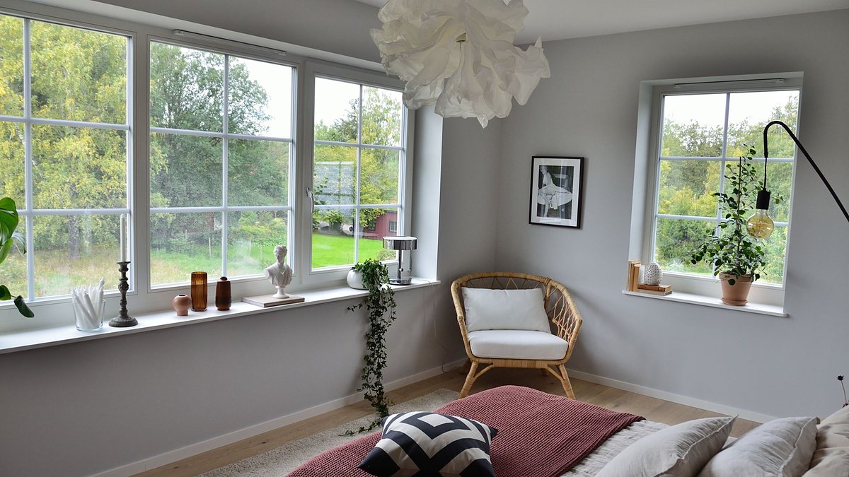 Scandinavian-style bedroom with large windows, natural light and greenery