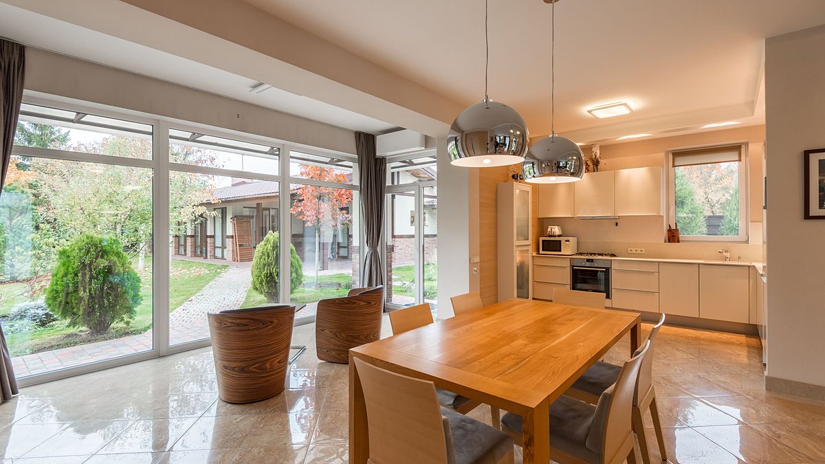 Bright, open modern kitchen with dining area overlooking a garden through large windows