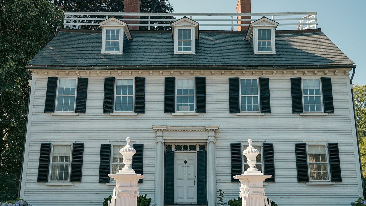 Colonial-style house with black shutters and a white picket fence in Salem, Massachusetts