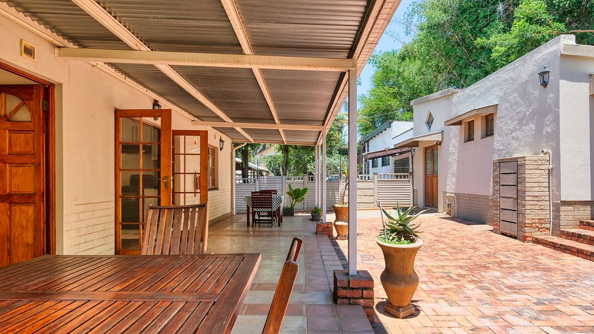 Terrace with wooden furniture and potted plants at a luxury home