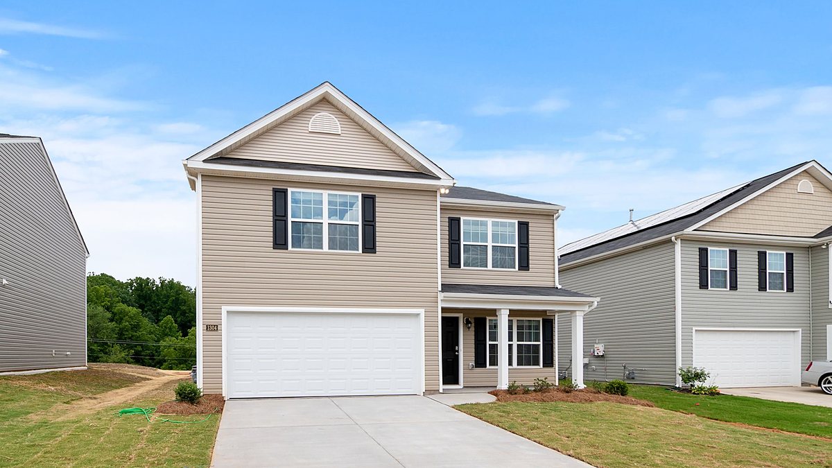Contemporary two-story suburban home with a spacious driveway and lawn